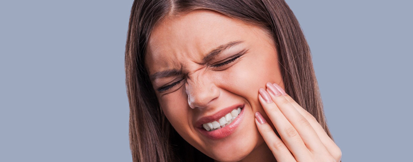 Woman holding her cheek from tooth pain